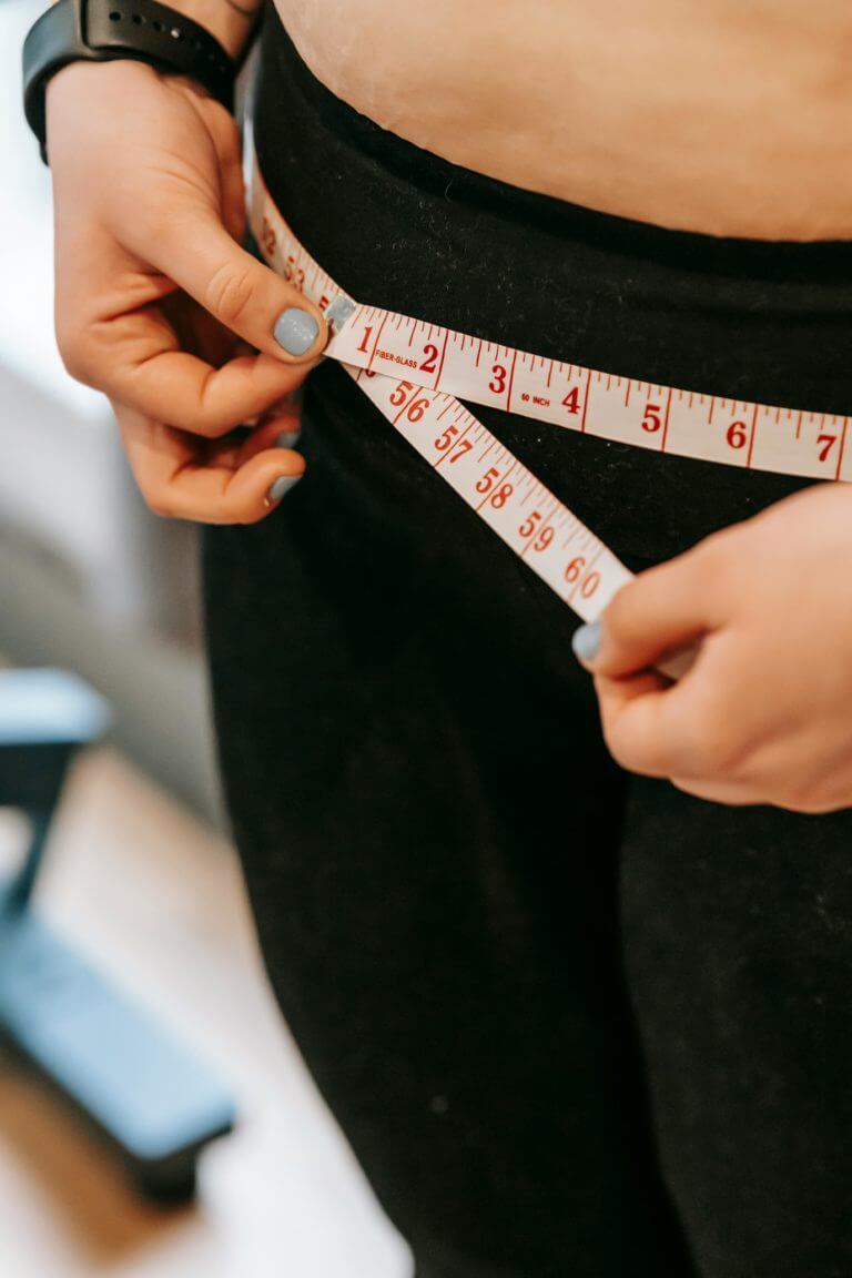 woman measuring waste line weight loss