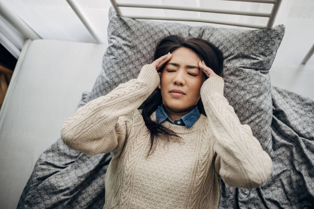 woman laying down with severe migraines