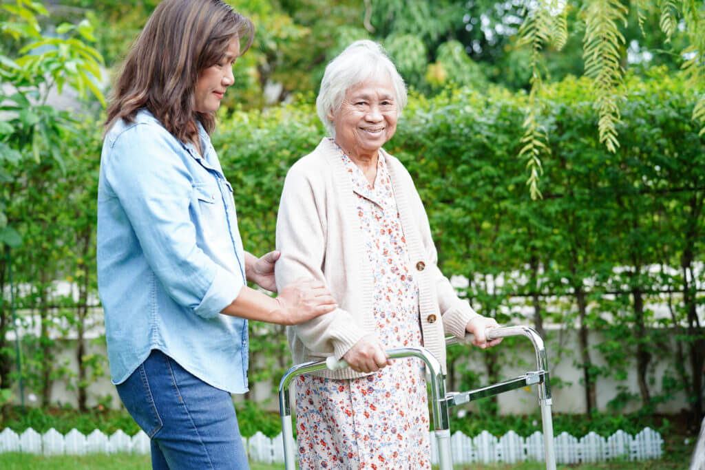 senior with dementia with caregiver on walk outside