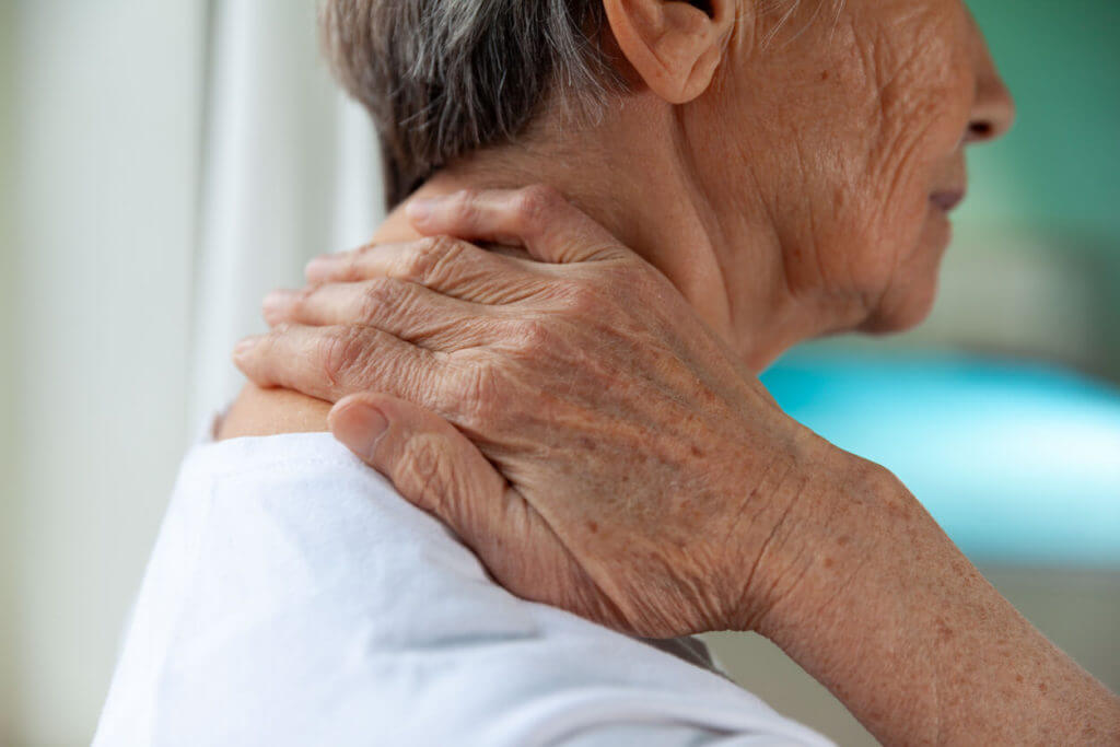 Close up of an elder person with chronic neck pain.