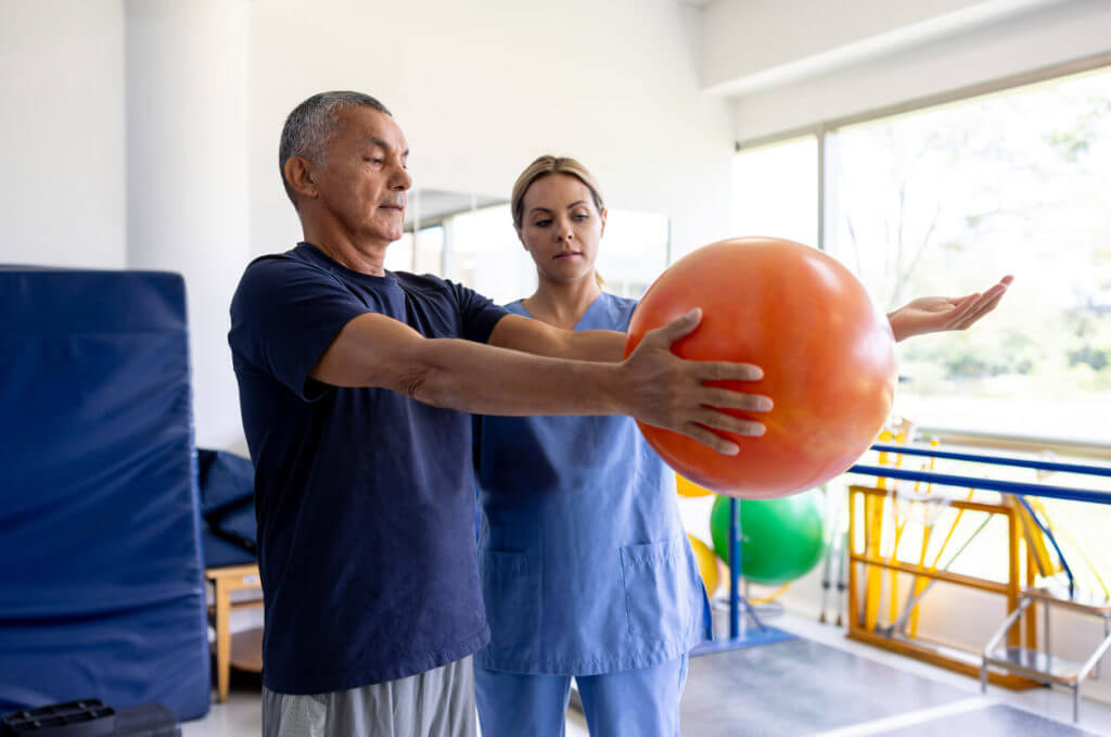 A man is undergoing physical therapy at a rehabilitation center for stroke recovery.